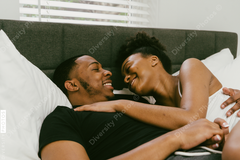 Young couple relaxing on bed at home, African American boyfriend and girlfriend love connection